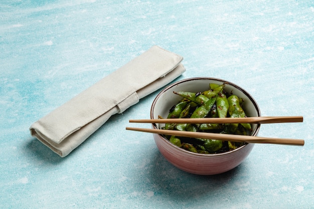 Edamame cozido em uma mesa azul. lanche de vagens de soja