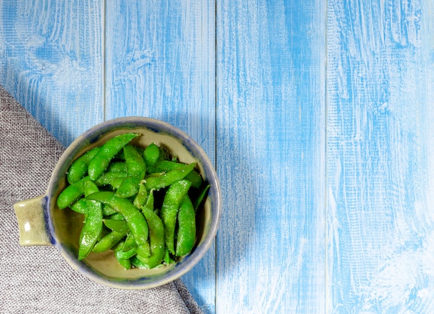 Edamame mordisquea en una taza