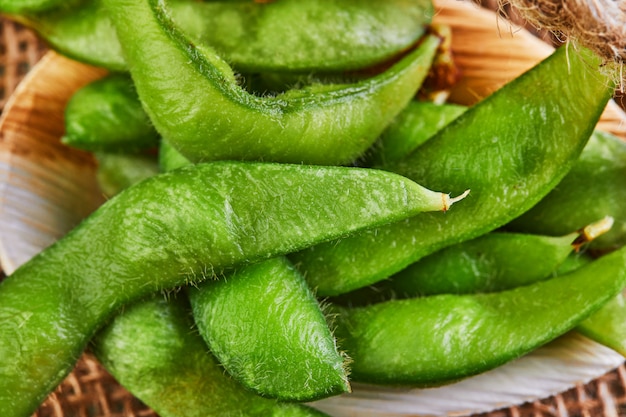 Edamame ou soja em uma placa de madeira em um saco de carvão