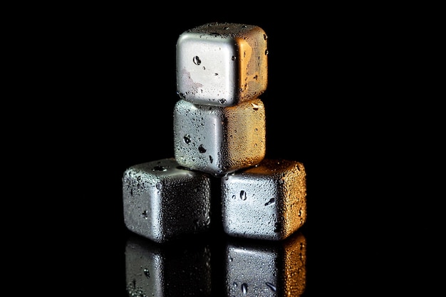 Edelstahlwürfel, die Eis zum Kühlen von Getränken auf einer schwarzen Oberfläche mit Reflexion simulieren