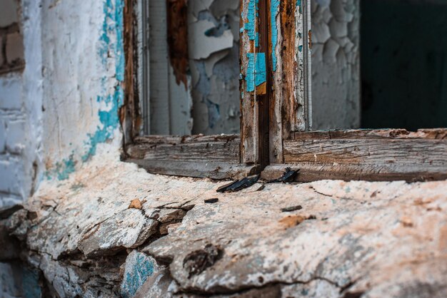 Edifício abandonado após a luta Moldura de madeira sem vidro e peitoril da janela de uma casa destruída e velha