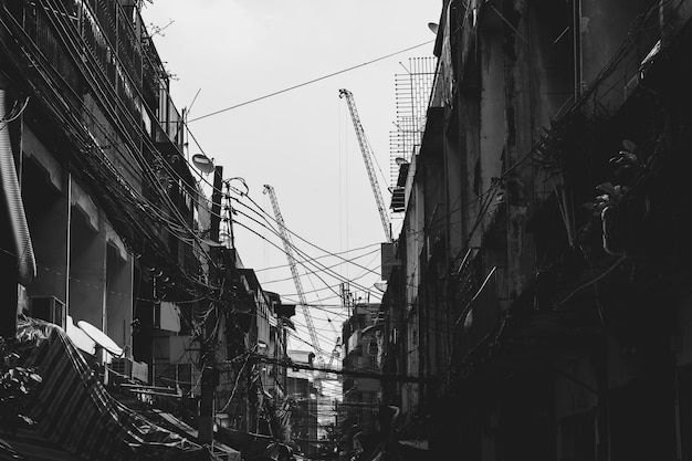 edificio abandonado en barrios marginales con cables eléctricos desordenados en tono blanco