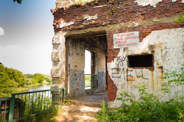 Edificio abandonado con un cartel Atención el paso está prohibido la amenaza de derrumbe