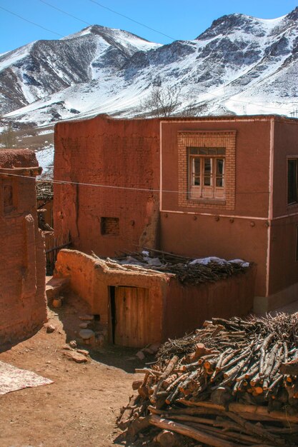 Edificio abandonado junto a una montaña cubierta de nieve contra el cielo