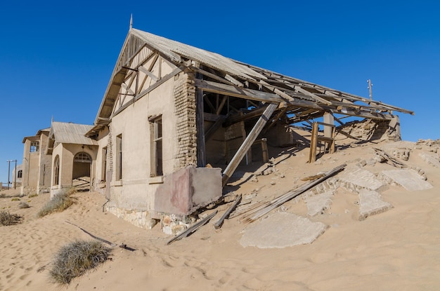 Foto edifício abandonado no deserto contra o céu limpo na cidade fantasma de kolmanskop, namíbia