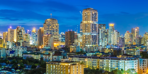 Edificio alto moderno del centro de ciudad de negocios de Bangkok en el crepúsculo.