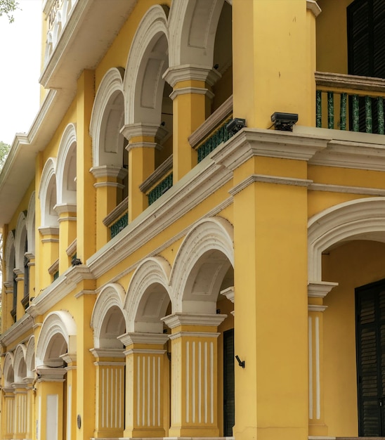 Un edificio amarillo con arcos y un borde blanco.