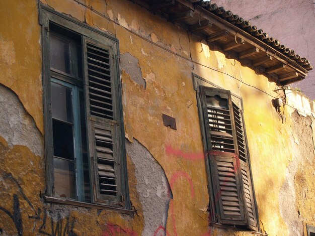 Un edificio amarillo con graffiti en el costado y la palabra "viejo" en el costado.