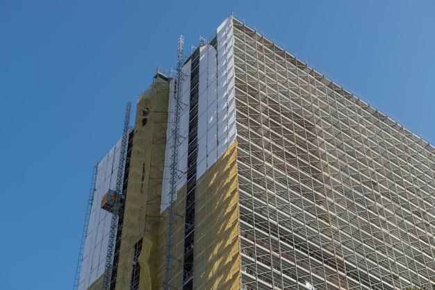 Edificio con andamios y láminas protectoras