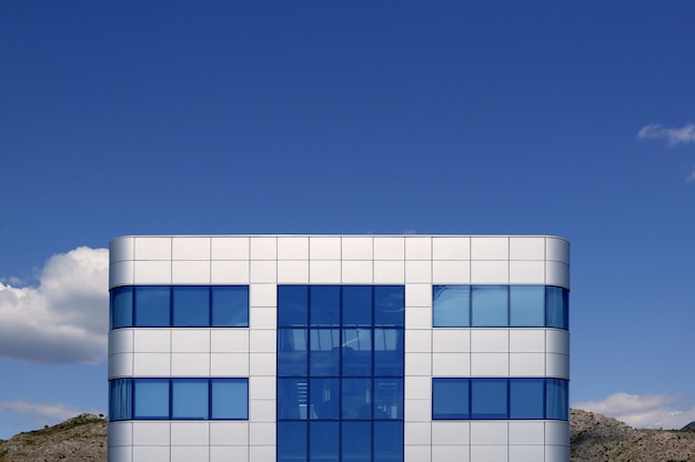 Edificio de arquitectura cúbica de cristal azul y plata.