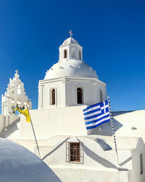 Edificio blanco del templo con un campanario en la isla Santorini.