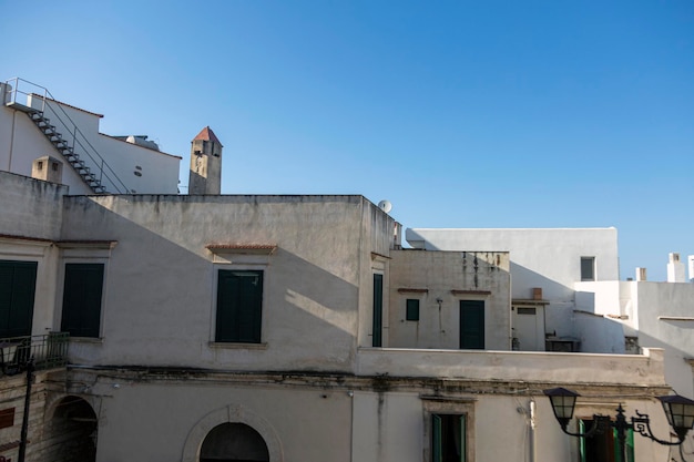 Un edificio blanco con una torre de reloj al fondo.