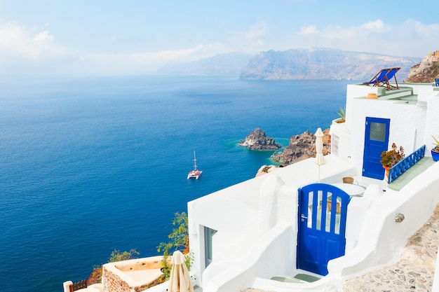 Edifício branco com portas azuis na ilha de Santorini, Grécia. Bela paisagem de verão, vista para o mar.