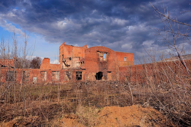 Un edificio en un campo con un cielo nublado