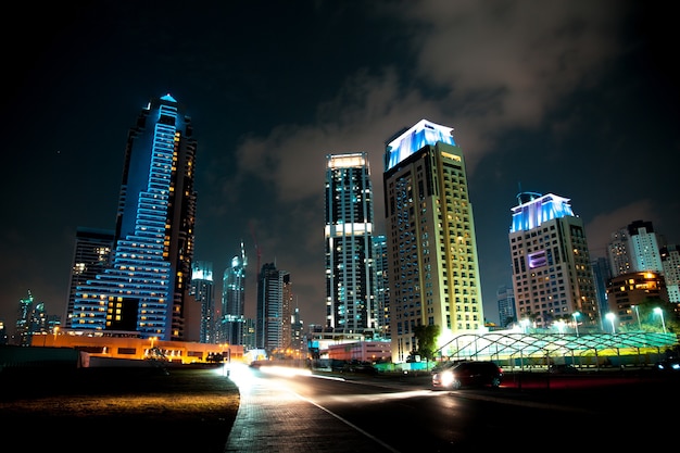 Edificio y carretera en la luz de la noche en Dubai