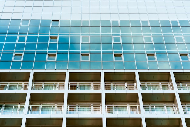 Edificio de cristal azul con balcones.