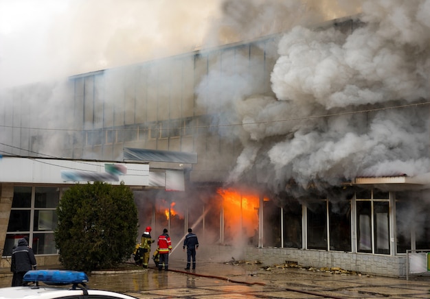 Foto edificio cubierto de fuego y humo fuerte. situacion peligrosa