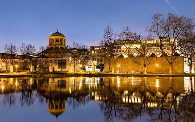 Edifício de arte com reflexo em um lago em stuttgart, alemanha