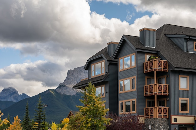 Edifício de madeira com montanhas rochosas na floresta de outono no centro de canmore, canadá