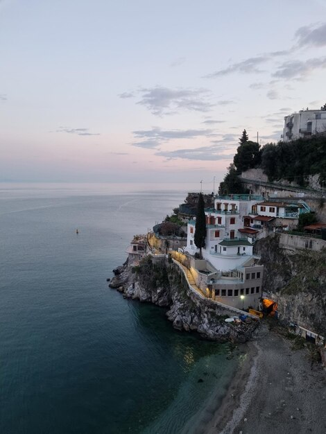 Foto un edificio se encuentra en un acantilado con vistas al océano