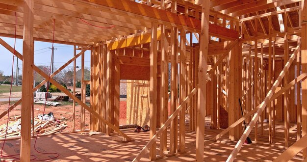 Edificio de estructura de madera en construcción en vigas de palo nuevas suburbanas construidas con pared