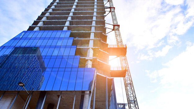 Edificio de gran altura en construcción Instalación de paneles de vidrio en la fachada
