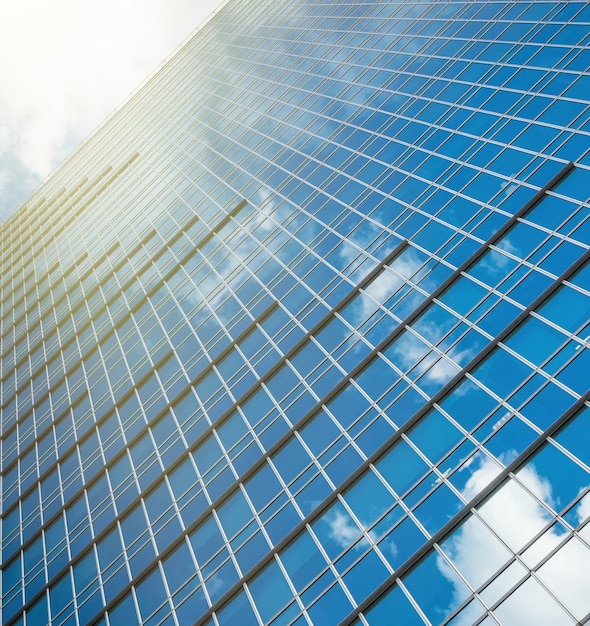 Edificio de gran altura de cristal moderno rascacielos sobre azul cielo claro brillante con luz solar