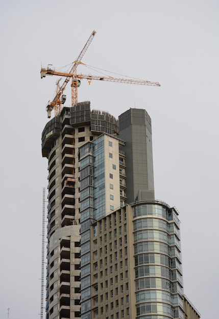 Foto edificio de gran altura con grúa de mosquito de construcción en la parte superior