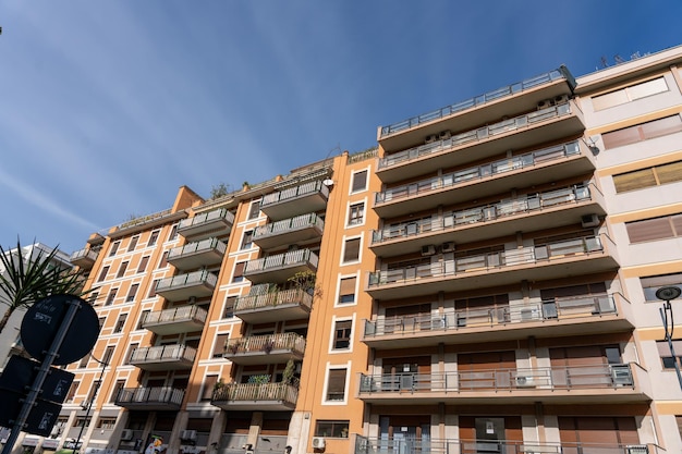 Un edificio grande con balcones y un letrero en el lado