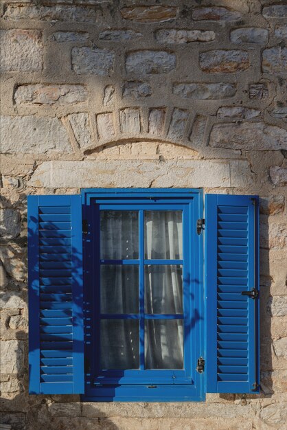 Un edificio gris con marcos de ventanas azules en el concepto de arquitectura y viajes de estilo griego