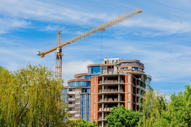 Edificio de hormigón en construcción Fondo del sitio de construcción Grúa cerca del edificio