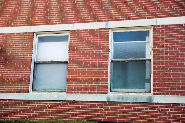 Un edificio de ladrillo rojo con una ventana y una persiana blanca.