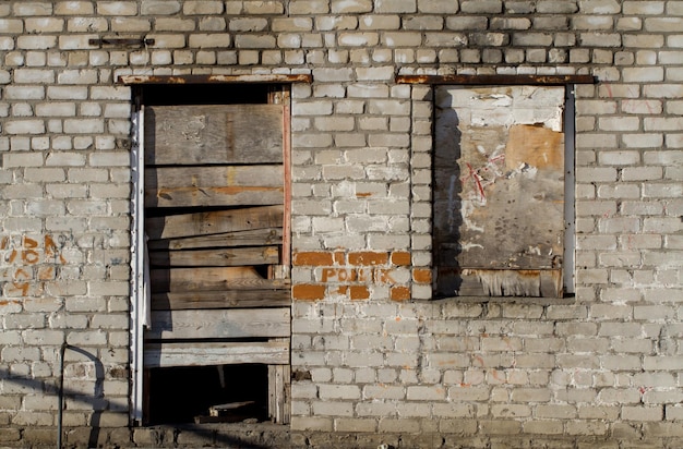 Edificio de ladrillo en ruinas con ventanas tapiadas