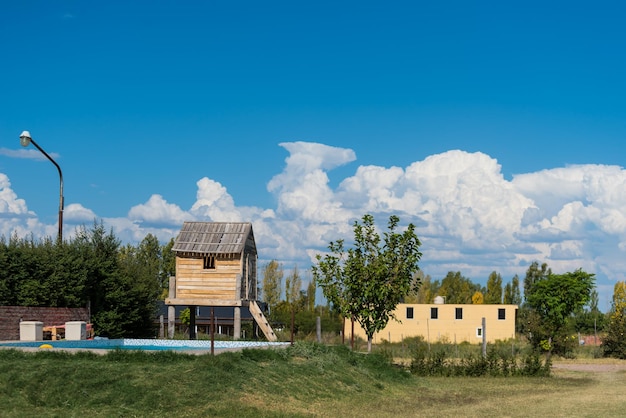 Un edificio de madera con un cielo azul y nubes al fondo.