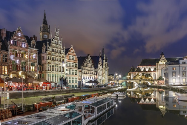 Edifício medieval pitoresco e ponte de St Michael no cais Graslei no rio Leie na cidade de Ghent à noite, Bélgica