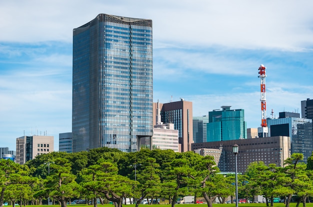 Foto edifício moderno com o jardim verde do zen no céu azul no tóquio, japão.