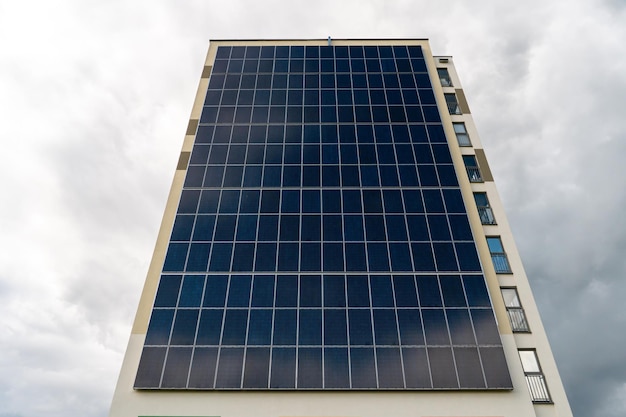 Un edificio moderno de bajo consumo contra el fondo de las nubes Edificio residencial de varios pisos con paneles solares en la pared Fuentes de energía renovables en la ciudad