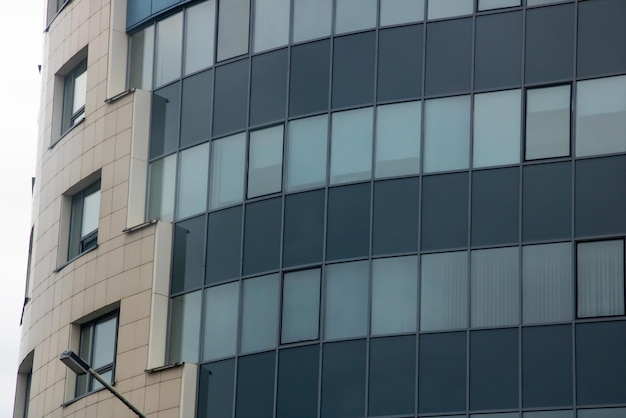 Edifício moderno de vidro alto contra um céu cinza