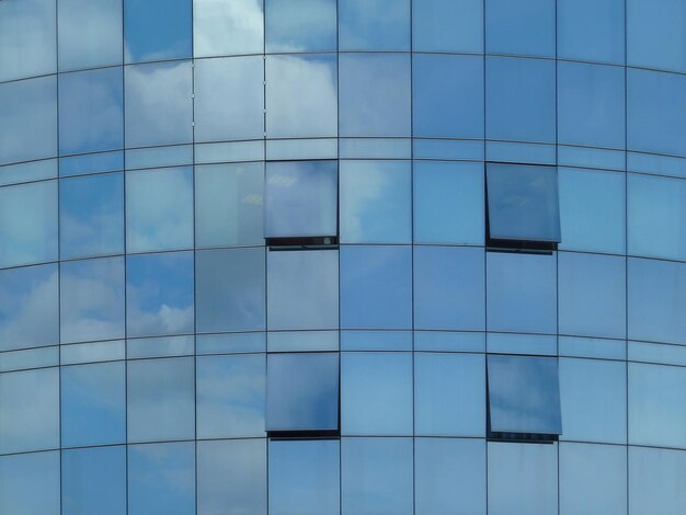 Edificio moderno con reflejos del cielo y ventanas abiertas