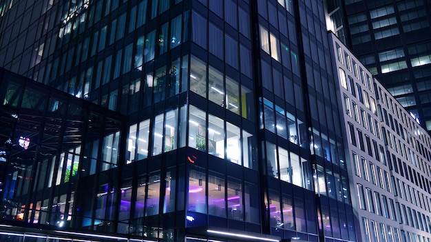 Edificio de oficinas moderno en la ciudad por la noche Vista en oficinas iluminadas de un edificio corporativo
