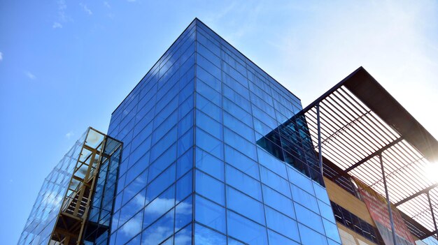 Edificio de oficinas moderno con fachada de vidrio en un fondo de cielo despejado Pared de vidrio transparente