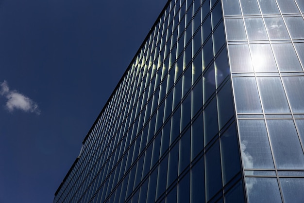 Edificio de oficinas moderno con fachada de vidrio sobre un fondo de cielo despejado Pared de vidrio transparente del edificio de oficinas