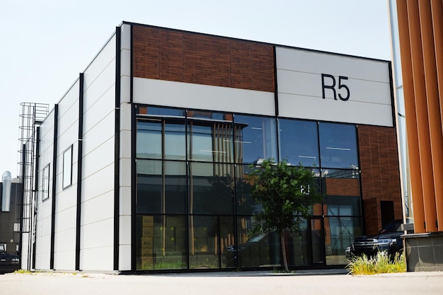 Edificio de oficinas moderno con señalización r5 que refleja los árboles