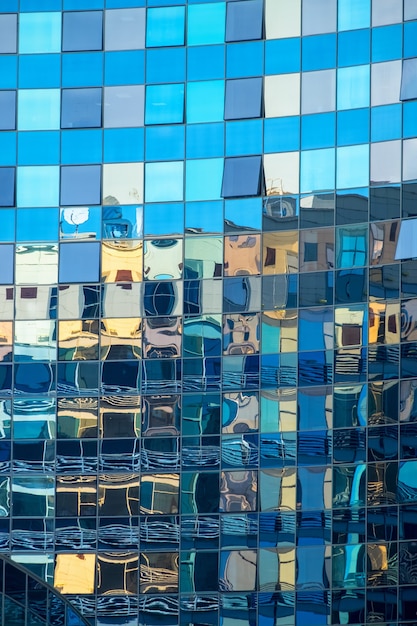 Edificio de oficinas se refleja en la fachada de cristal de otro edificio de oficinas