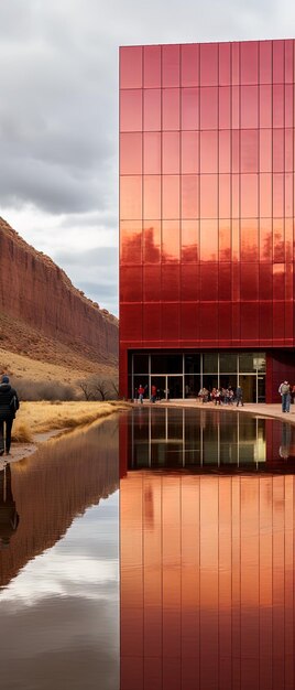 Foto un edificio con una pared roja y un reflejo de un edificio en el agua