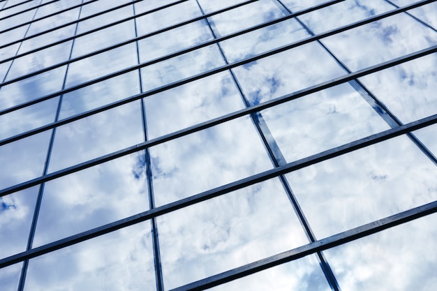 Edificio de rascacielos de cristal con fondo de cielo azul nublado