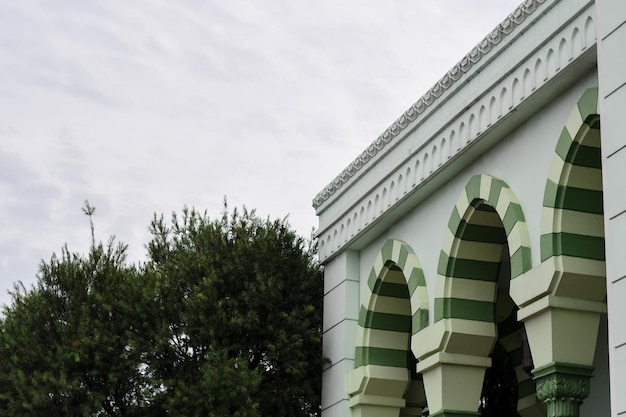 Un edificio con rayas verdes y blancas y un edificio blanco. fondo de la mezquita