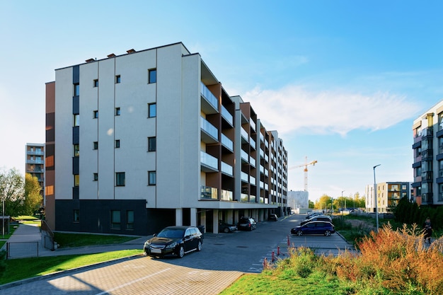 Edificio residencial de apartamentos y coches aparcados en la calle.