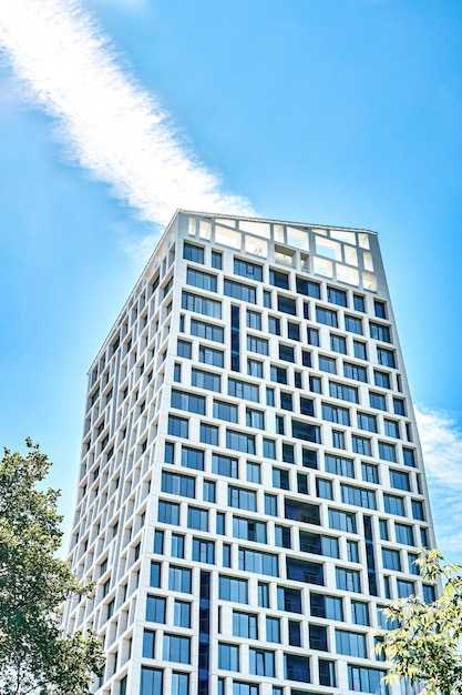 Edificio urbano contemporáneo de gran altura con diseño geométrico contra el cielo azul sin nubes en un día soleado