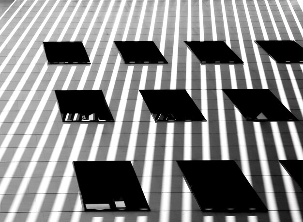 Un edificio con ventanas y sombras en la pared.